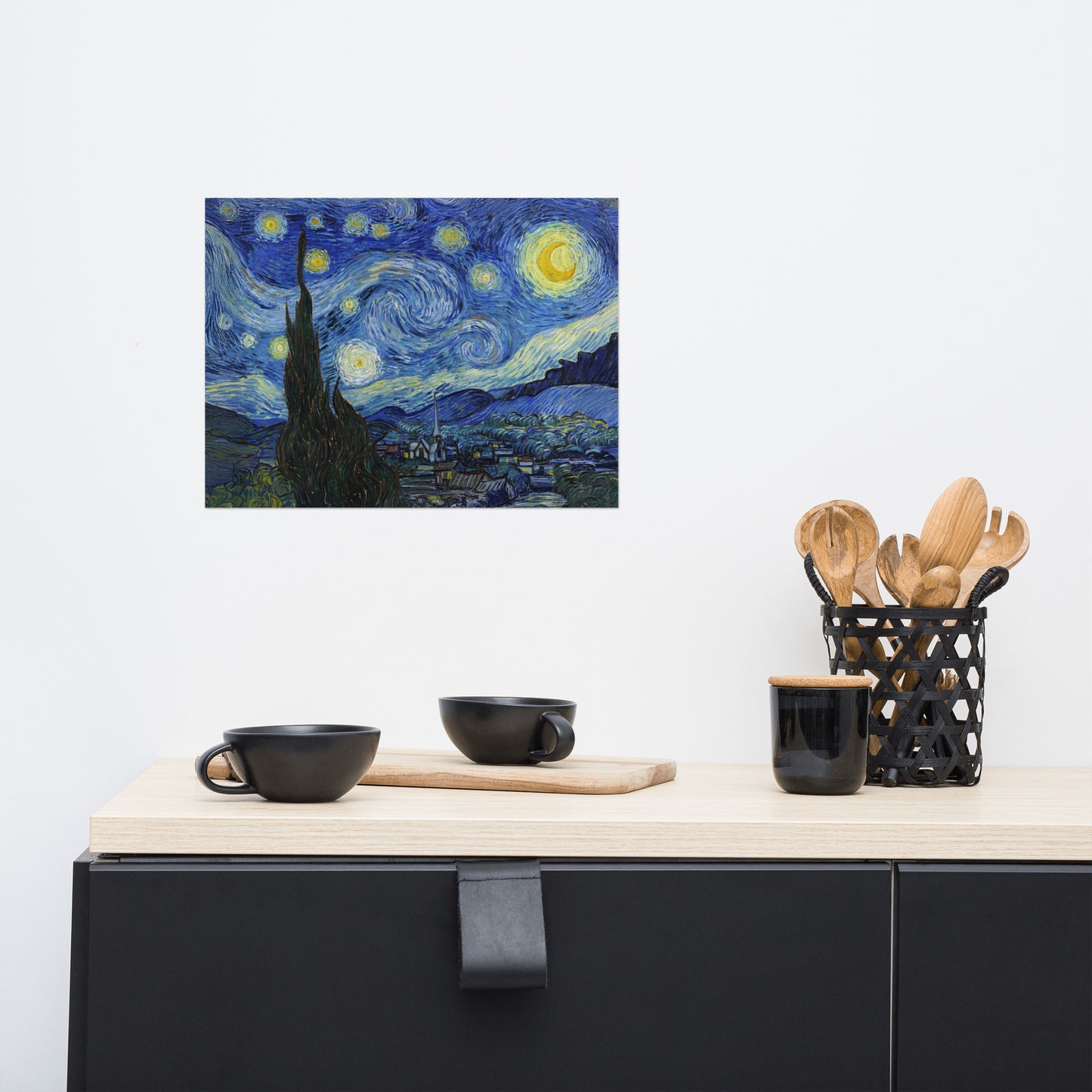 Van Gogh's 'Starry Night' on a 12"x16" unframed poster print on a white wall above a kitchen counter with cooking supplies.