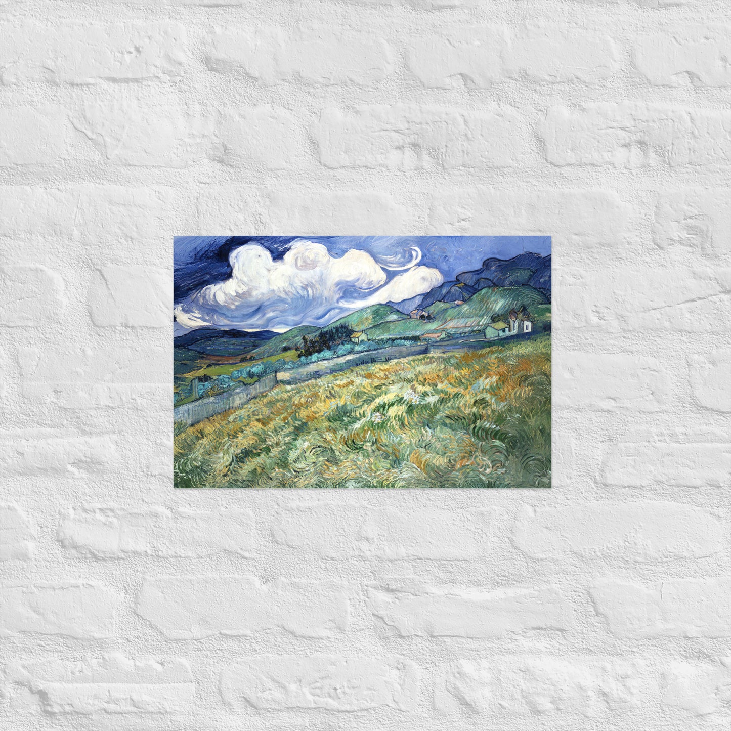 Van Gogh's 'Landscape from Saint-Rémy' on a 12"x18" unframed poster print on a white brick wall.