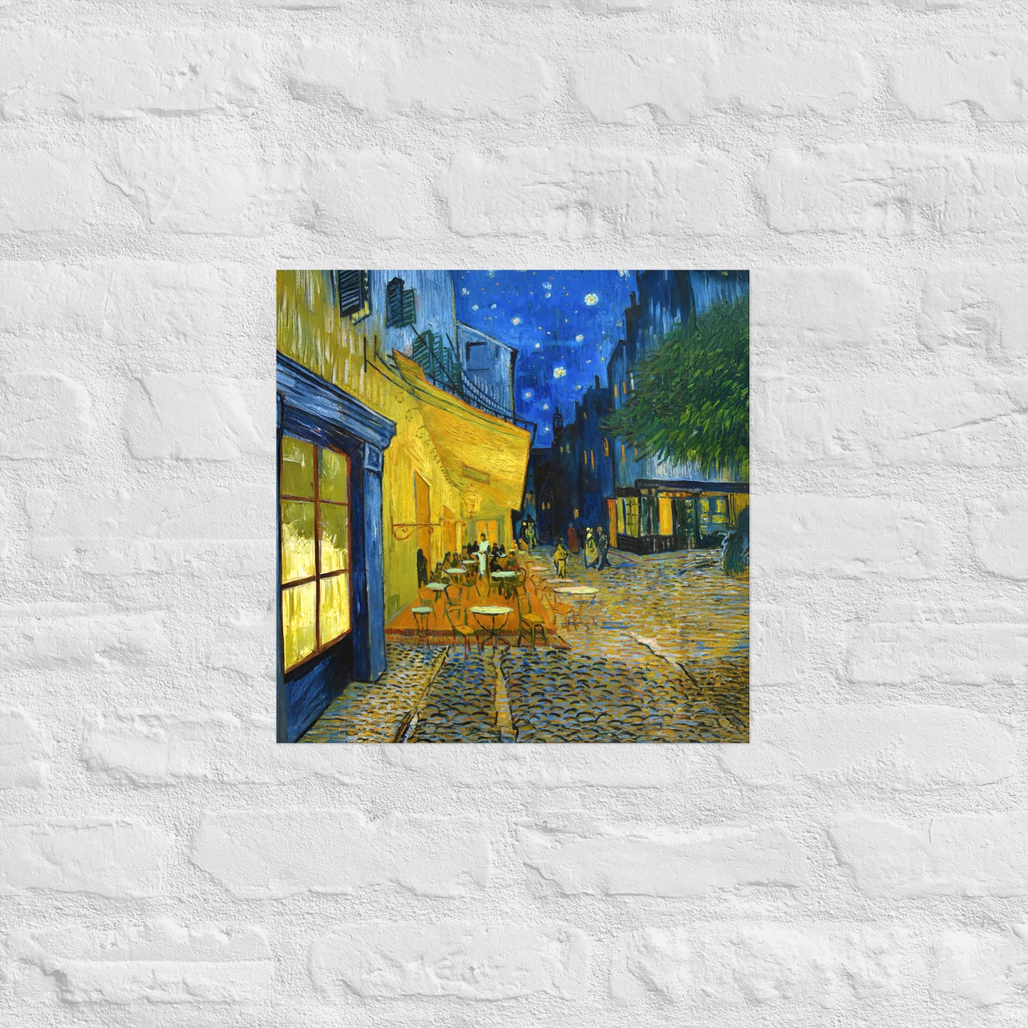 Van Gogh's 'Café Terrace at Night' on a 16"x16" unframed poster print on a white brick wall.
