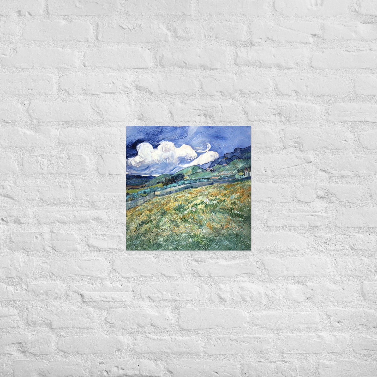 Van Gogh's 'Landscape from Saint-Rémy' on a 18"x18" unframed poster print on a white brick wall.