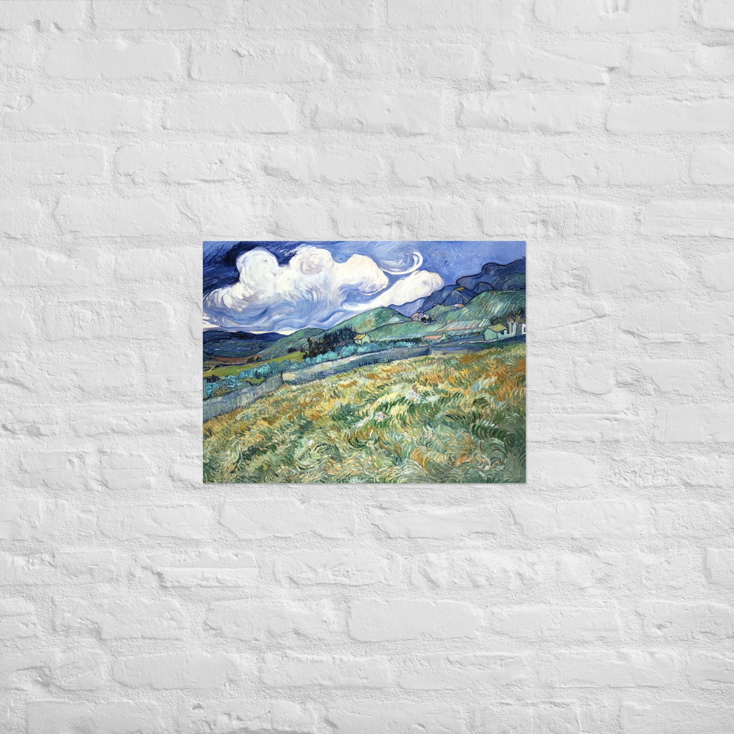 Van Gogh's 'Landscape from Saint-Rémy' on a 18"x24" unframed poster print on a white brick wall.