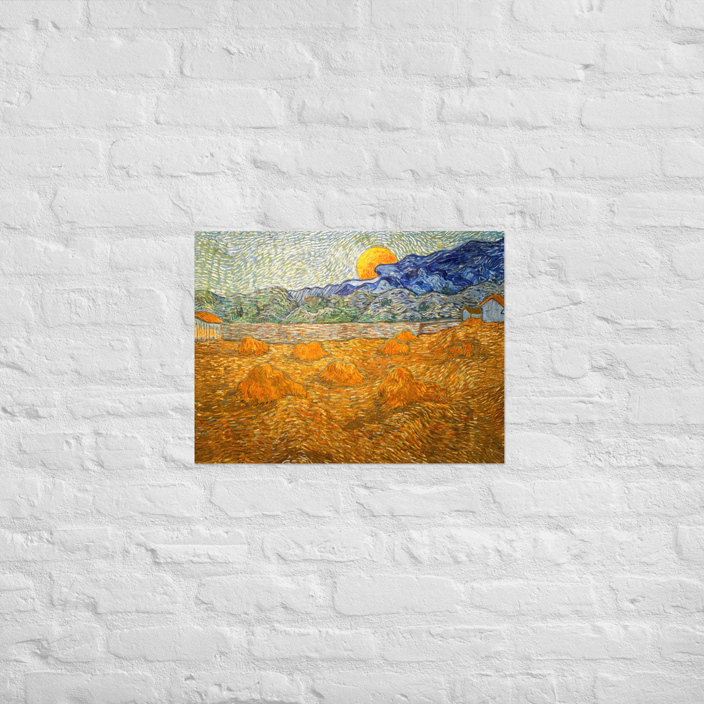 Van Gogh's 'Landscape with Wheat Sheaves and Rising Moon' on a 18"x24" unframed poster print on a white brick wall.
