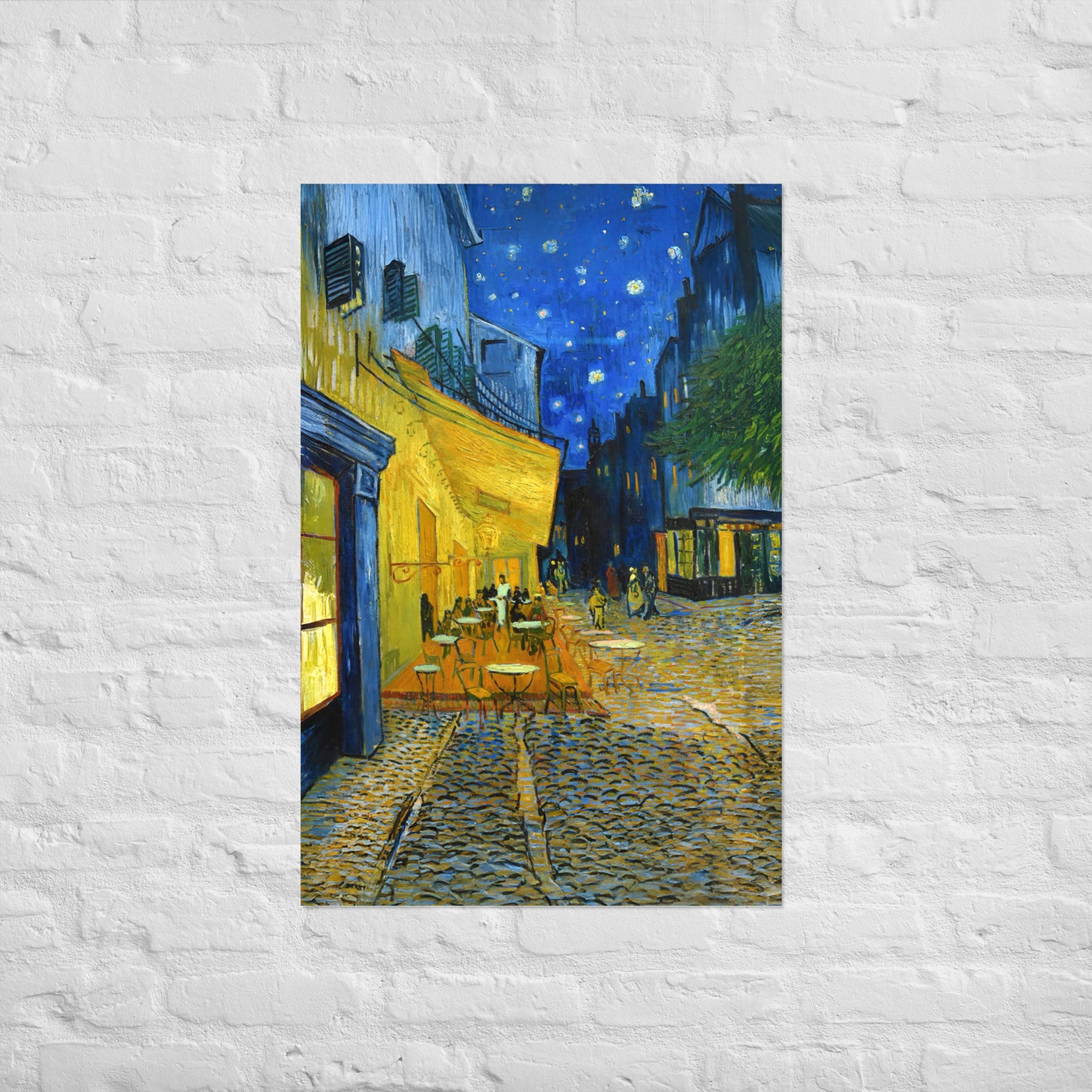 Van Gogh's 'Café Terrace at Night' on a 24"x36" unframed poster print on a white brick wall.