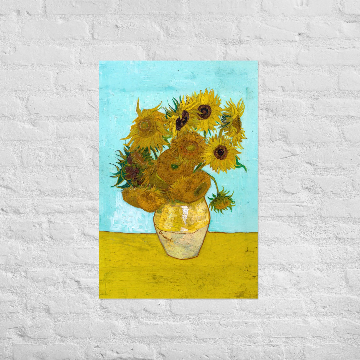 Van Gogh's 'Vase with Twelve Sunflowers' on a 24"x36" unframed poster print on a white brick wall.
