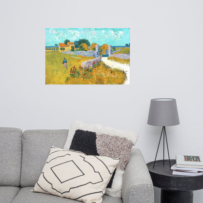Van Gogh's 'Farmhouse in Provence' on a 24"x36" unframed poster print on a white wall above a gray sofa with throw pillows and side table with a lamp.