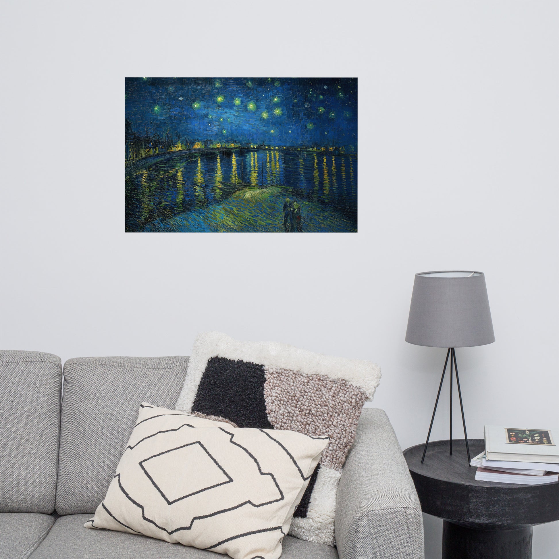 Van Gogh's 'Starry Night Over the Rhone' on a 24"x36" unframed poster print on a white wall above a gray sofa with throw pillows and side table with a lamp.
