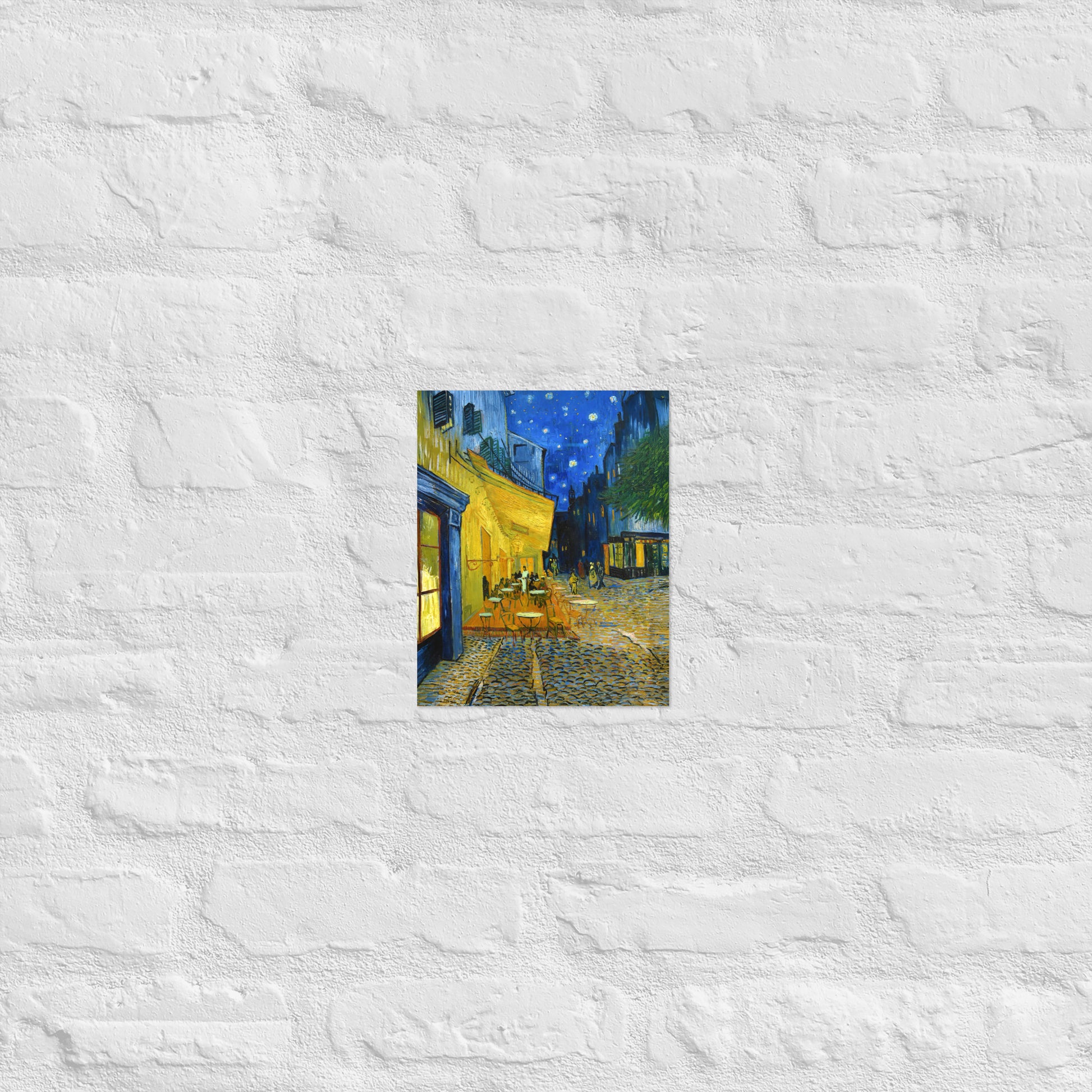 Van Gogh's 'Café Terrace at Night' on a 8"x10" unframed poster print on a white brick wall.