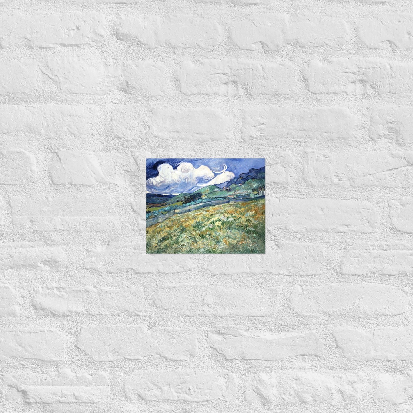 Van Gogh's 'Landscape from Saint-Rémy' on a 8"x10" unframed poster print on a white brick wall.