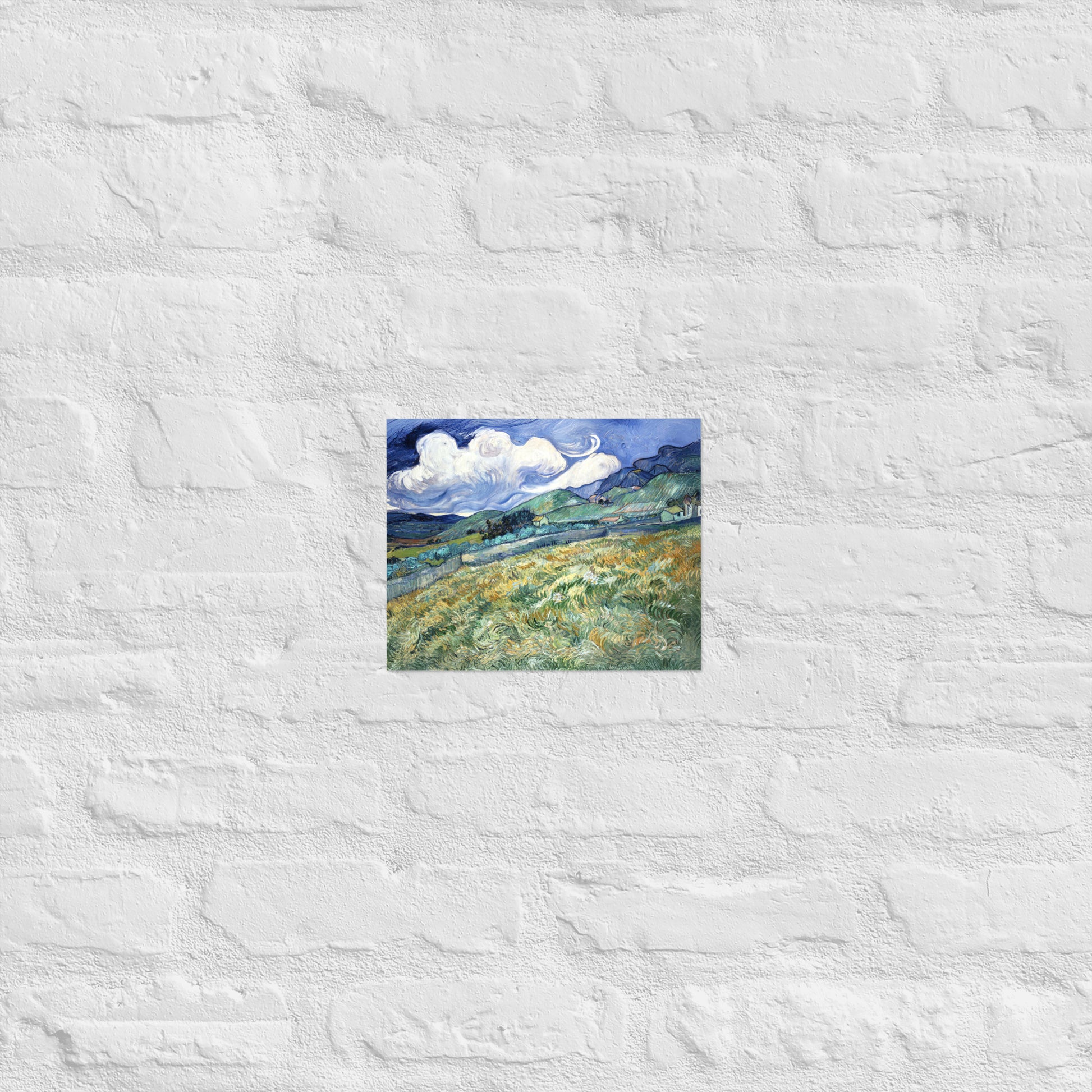Van Gogh's 'Landscape from Saint-Rémy' on a 8"x10" unframed poster print on a white brick wall.
