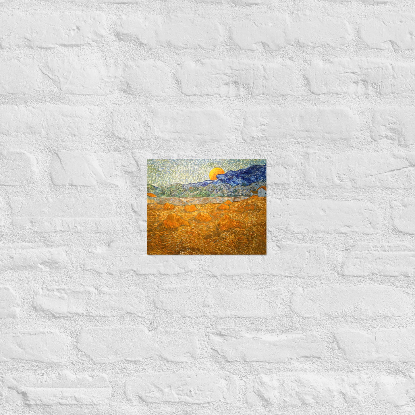 Van Gogh's 'Landscape with Wheat Sheaves and Rising Moon' on a 8"x10" unframed poster print on a white brick wall.