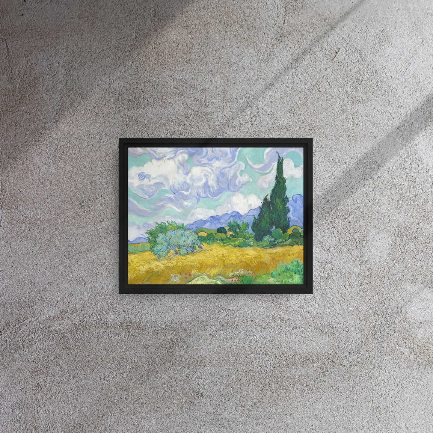 Van Gogh's 'Wheat Field with Cypresses' on a 11"x14" black framed canvas print on a textured gray wall.