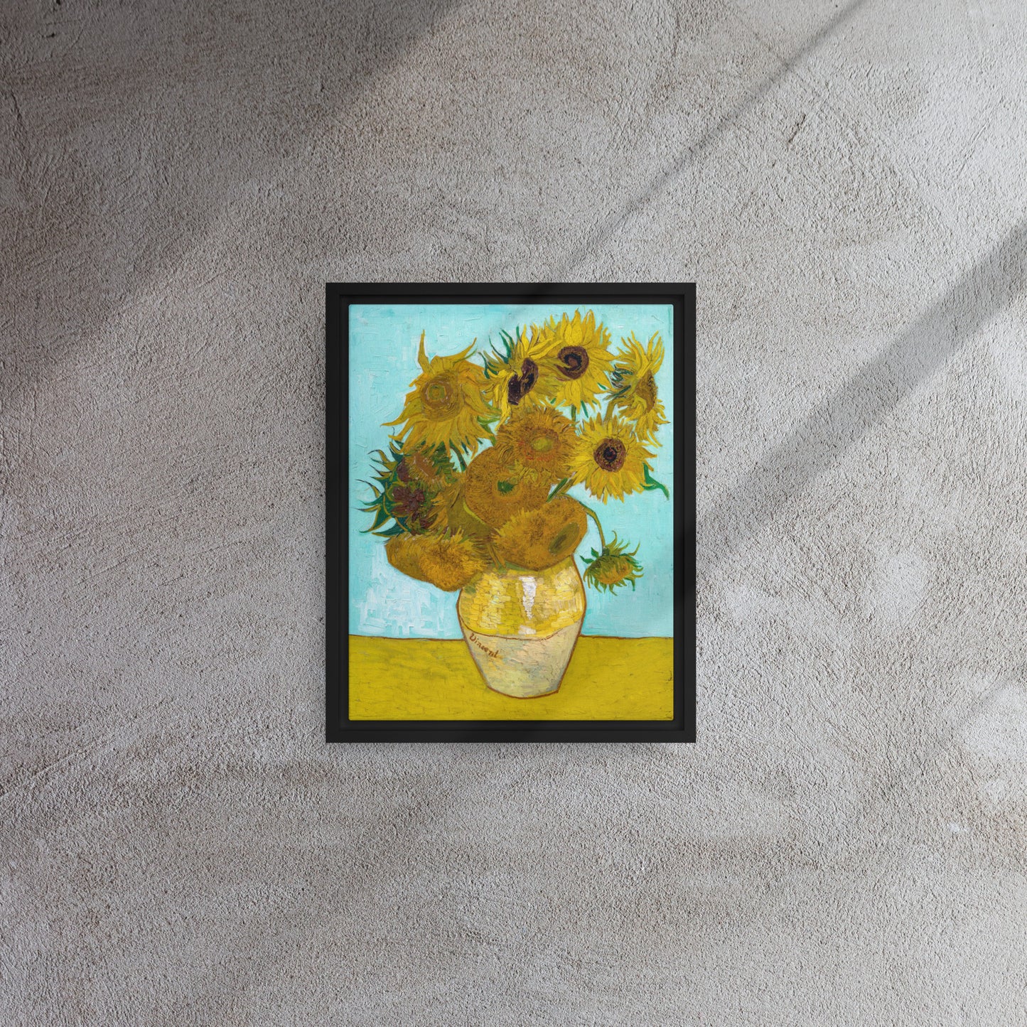 Van Gogh's 'Vase with Twelve Sunflowers' on a 11"x14" black framed canvas print on a textured gray wall.