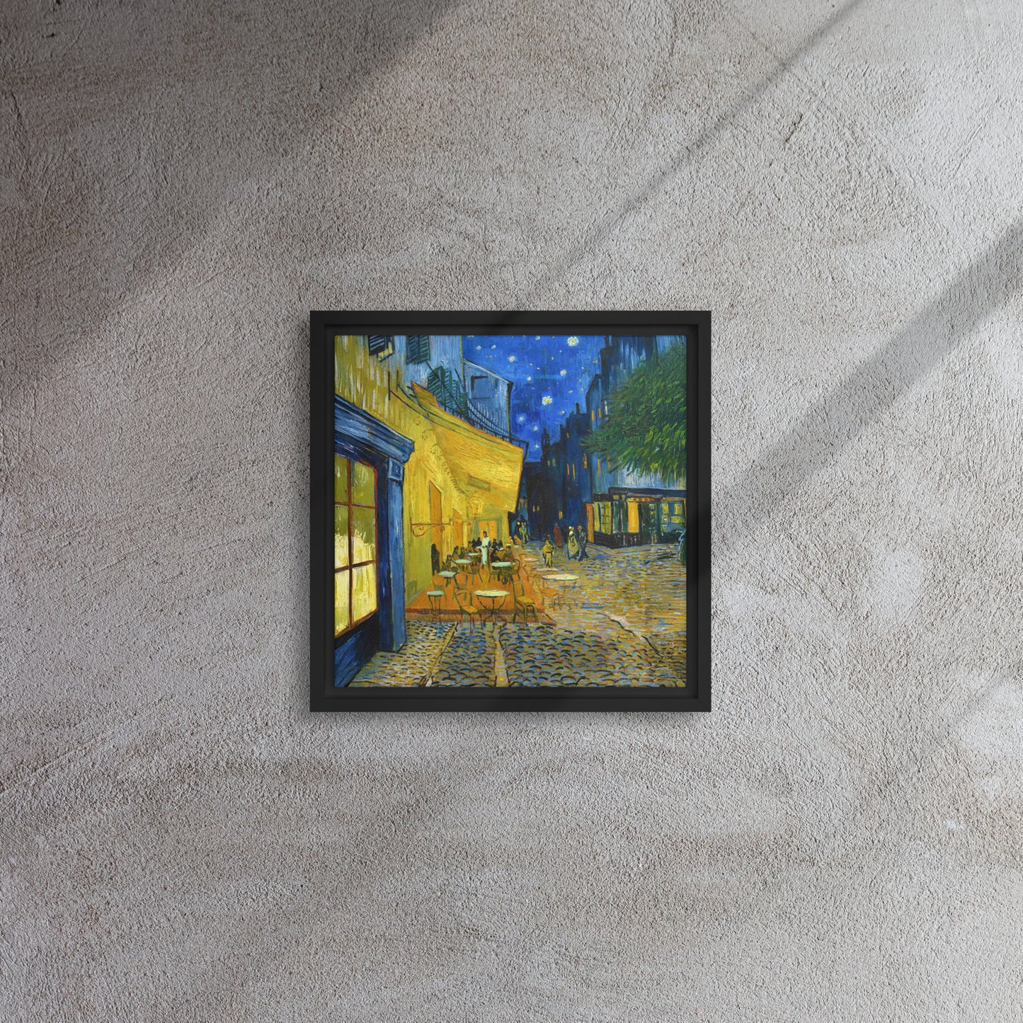Van Gogh's 'Café Terrace at Night' on a 12"x12" black framed canvas print on a textured gray wall.