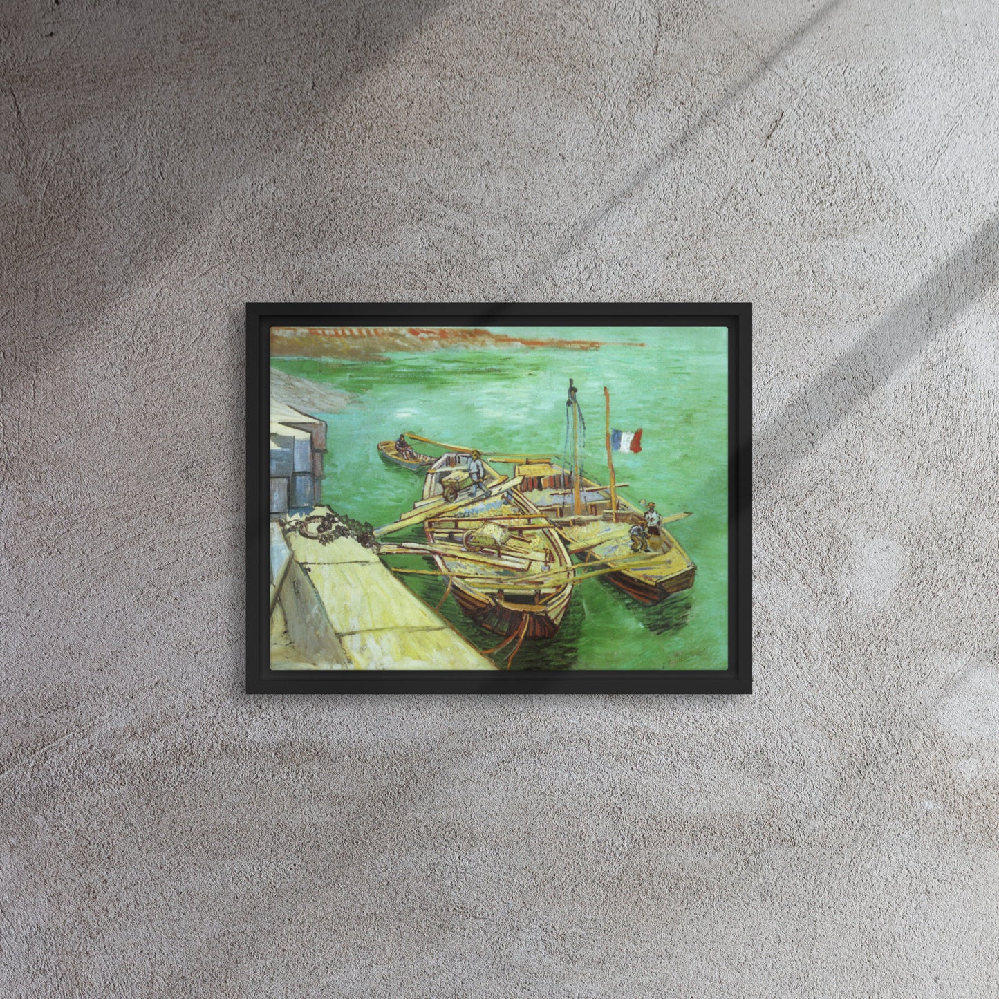 Van Gogh's 'Quay with Men Unloading Sand Barges' on a 12"x16" black framed canvas print on a textured gray wall.