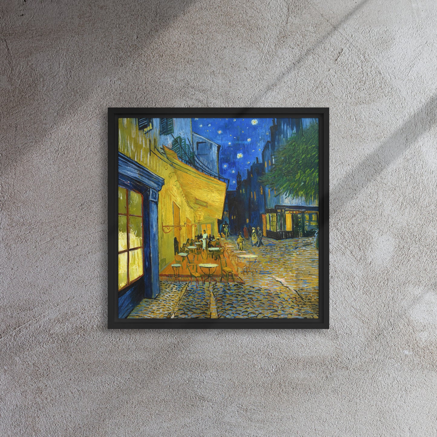 Van Gogh's 'Café Terrace at Night' on a 16"x16" black framed canvas print on a textured gray wall.