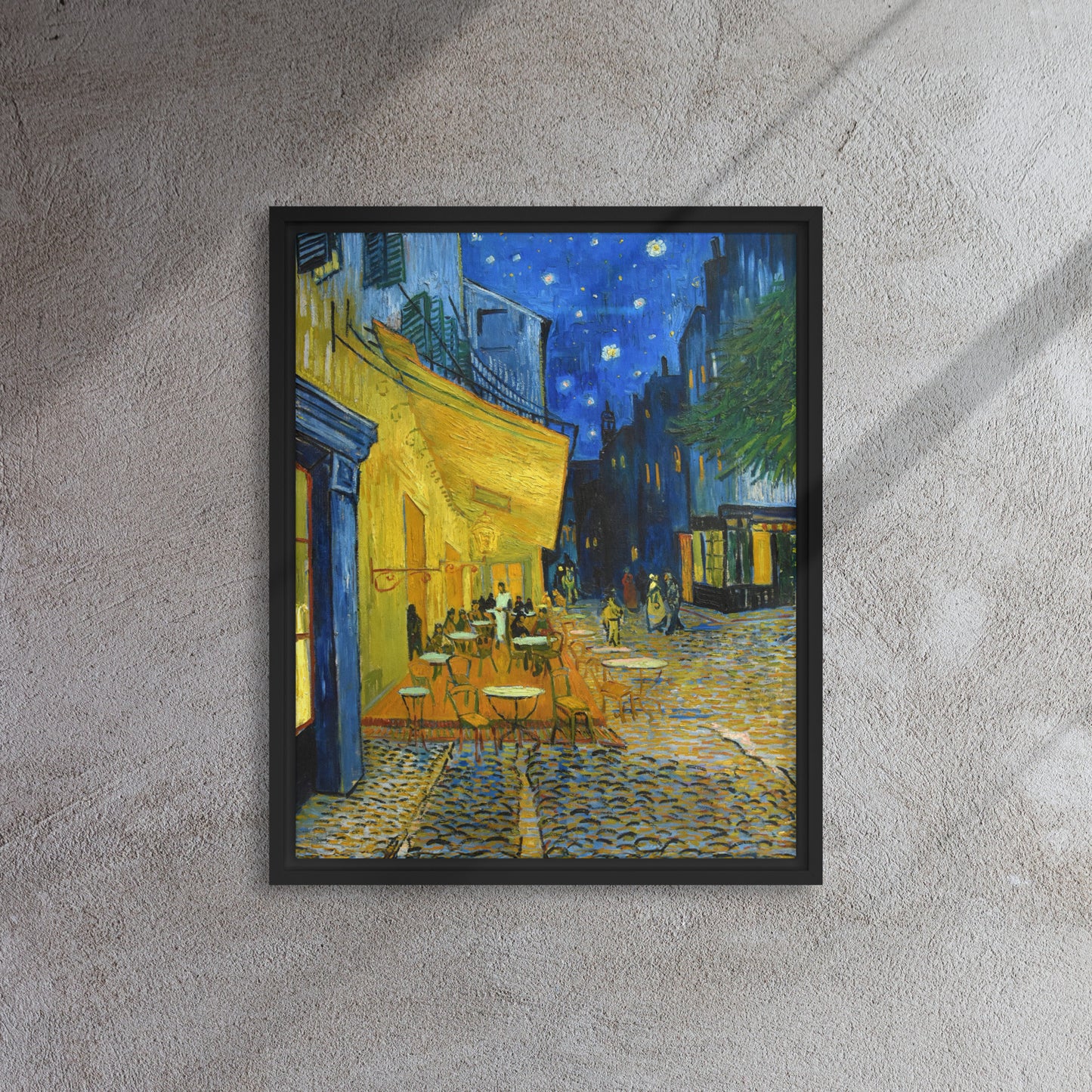 Van Gogh's 'Café Terrace at Night' on a 16"x20" black framed canvas print on a textured gray wall.