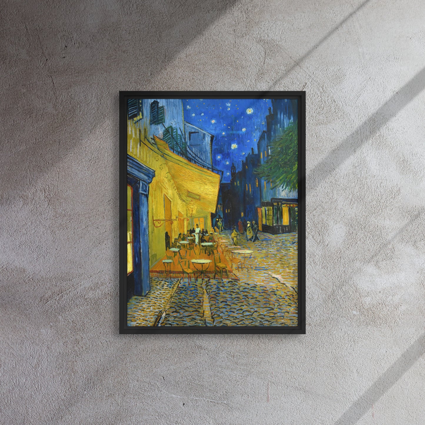 Van Gogh's 'Café Terrace at Night' on a 18"x24" black framed canvas print on a textured gray wall.