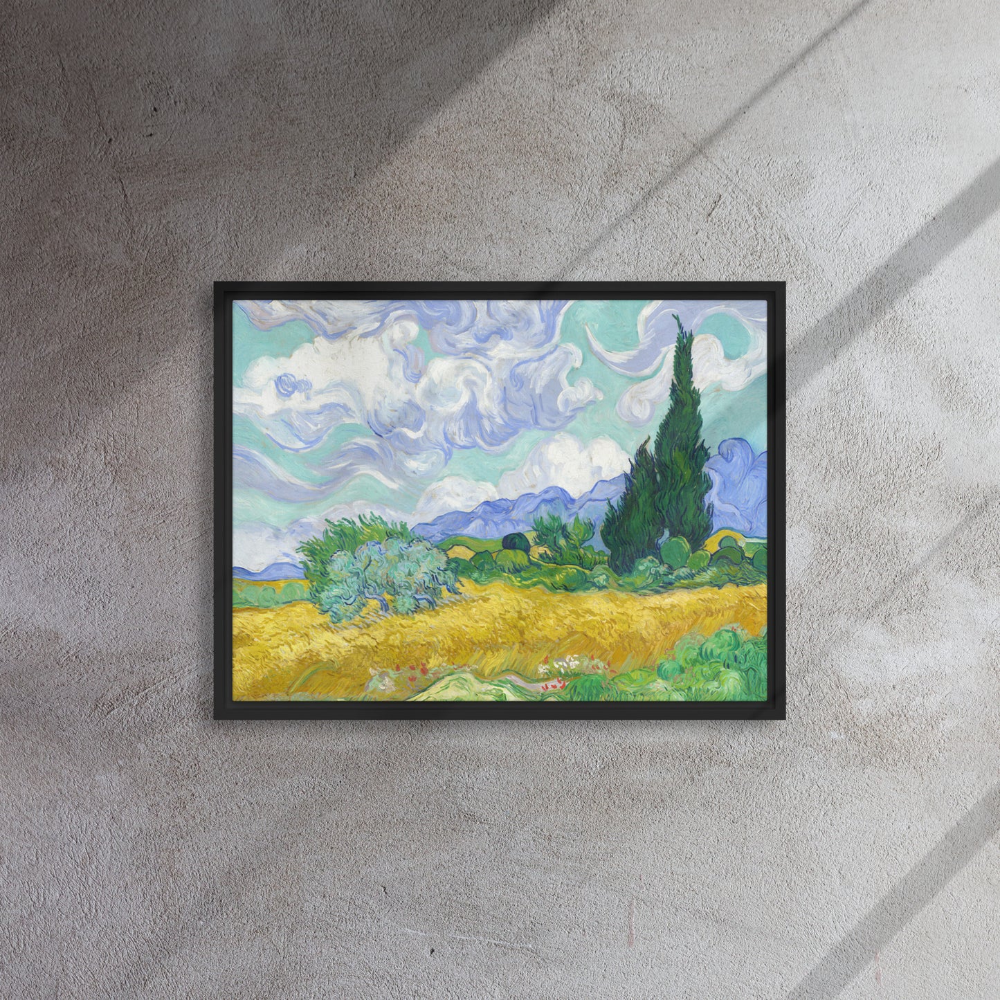 Van Gogh's 'Wheat Field with Cypresses' on a 18"x24" black framed canvas print on a textured gray wall.
