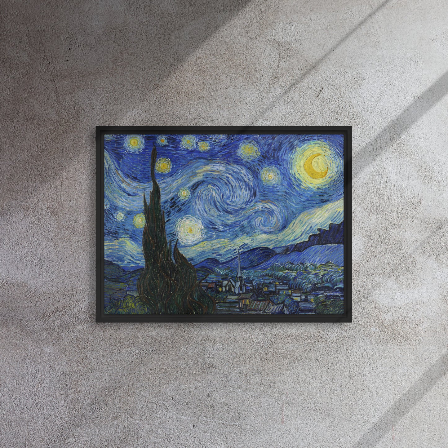 Van Gogh's 'Starry Night' on a 18"x24" black framed canvas print on a textured gray wall.