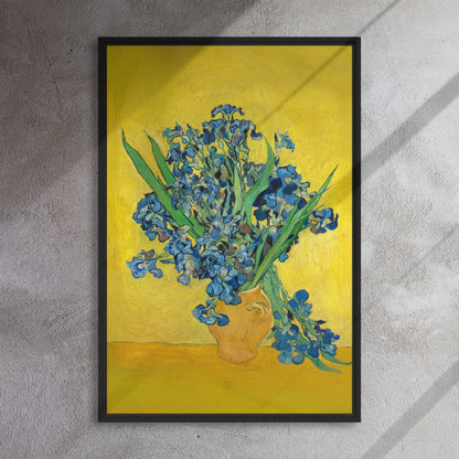 Van Gogh's 'Vase with Irises Against a Yellow Background' on a 24"x36" black framed canvas print on a textured gray wall.