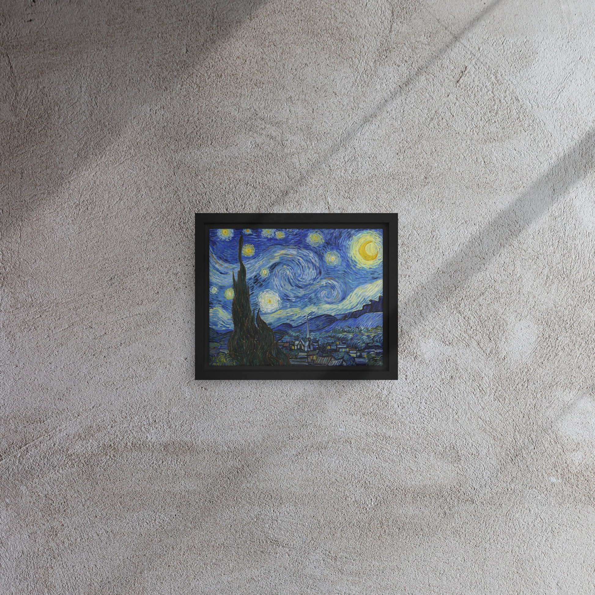 Van Gogh's 'Starry Night' on a 8"x10" black framed canvas print on a textured gray wall.