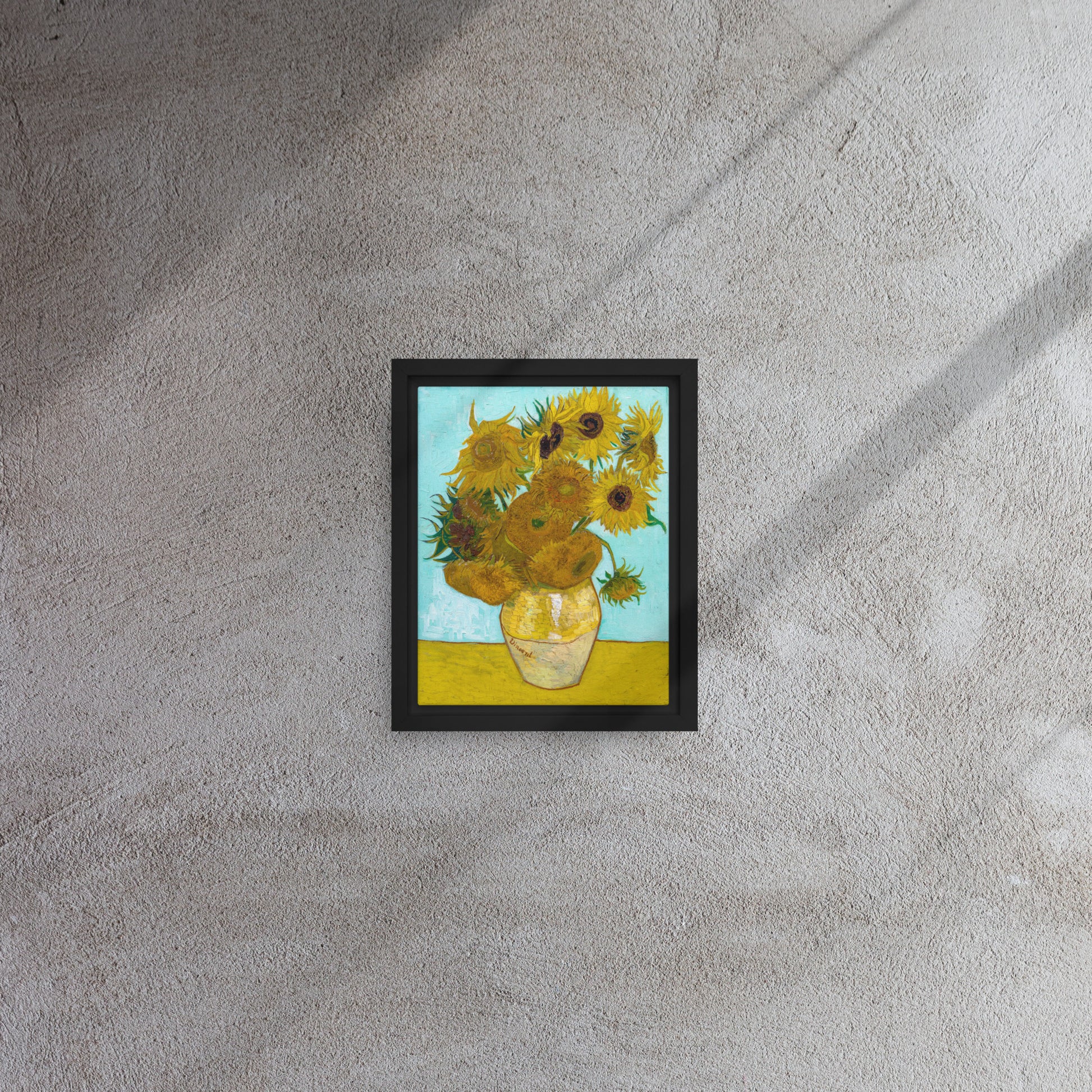 Van Gogh's 'Vase with Twelve Sunflowers' on a 8"x10" black framed canvas print on a textured gray wall.