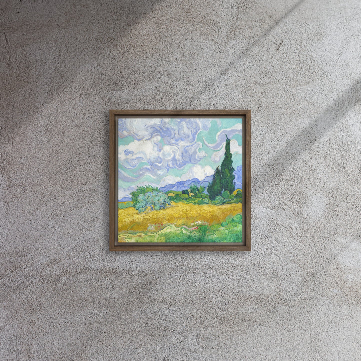 Van Gogh's 'Wheat Field with Cypresses' on a 12"x12" brown framed canvas print on a textured gray wall.