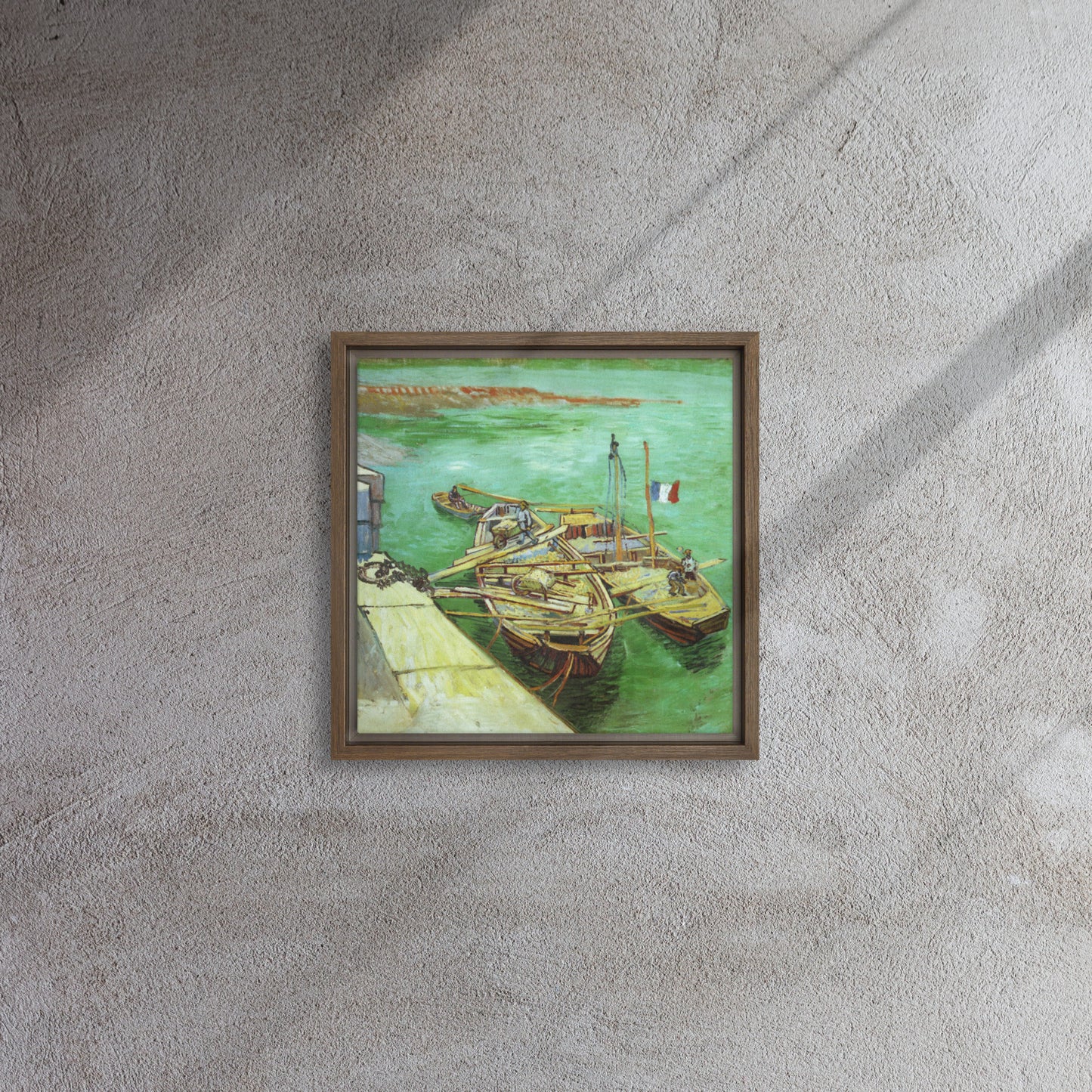 Van Gogh's 'Quay with Men Unloading Sand Barges' on a 12"x12" brown framed canvas print on a textured gray wall.