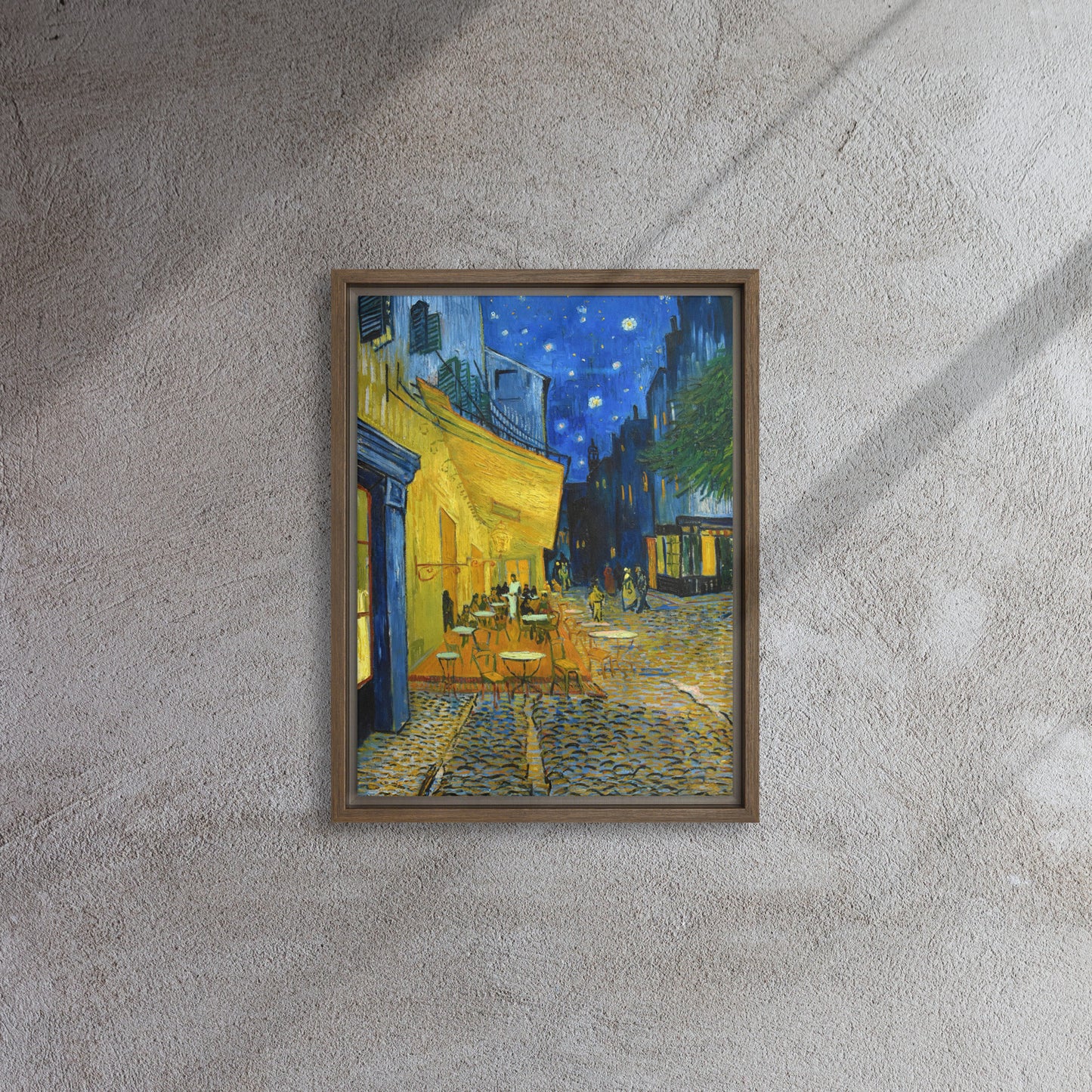 Van Gogh's 'Café Terrace at Night' on a 12"x16" brown framed canvas print on a textured gray wall.