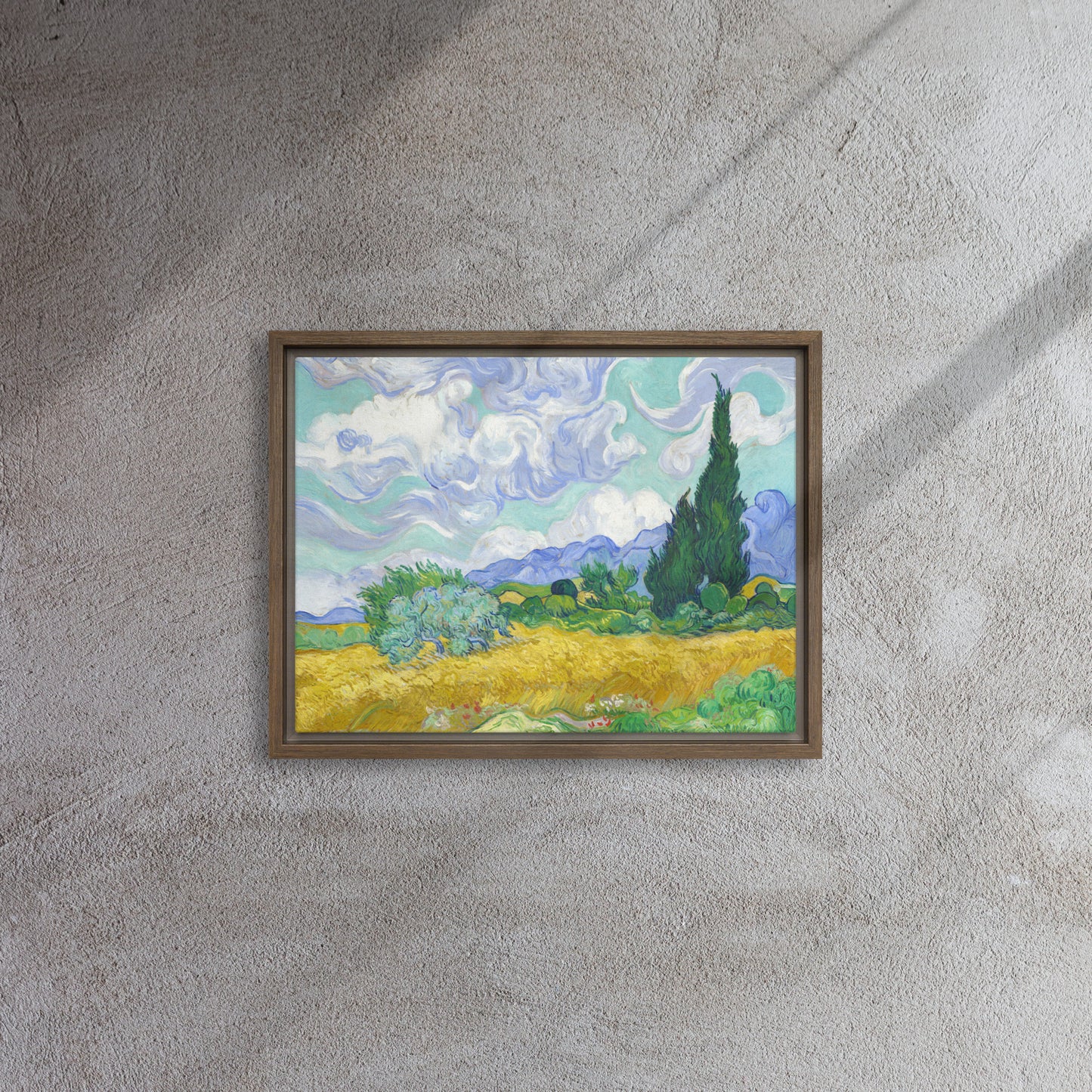 Van Gogh's 'Wheat Field with Cypresses' on a 12"x16" brown framed canvas print on a textured gray wall.