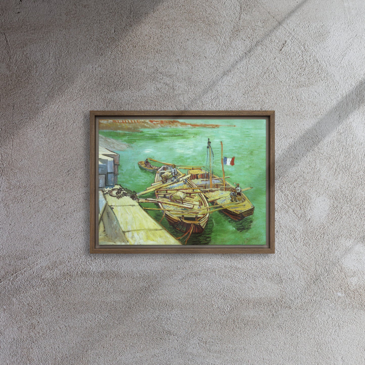 Van Gogh's 'Quay with Men Unloading Sand Barges' on a 12"x16" brown framed canvas print on a textured gray wall.