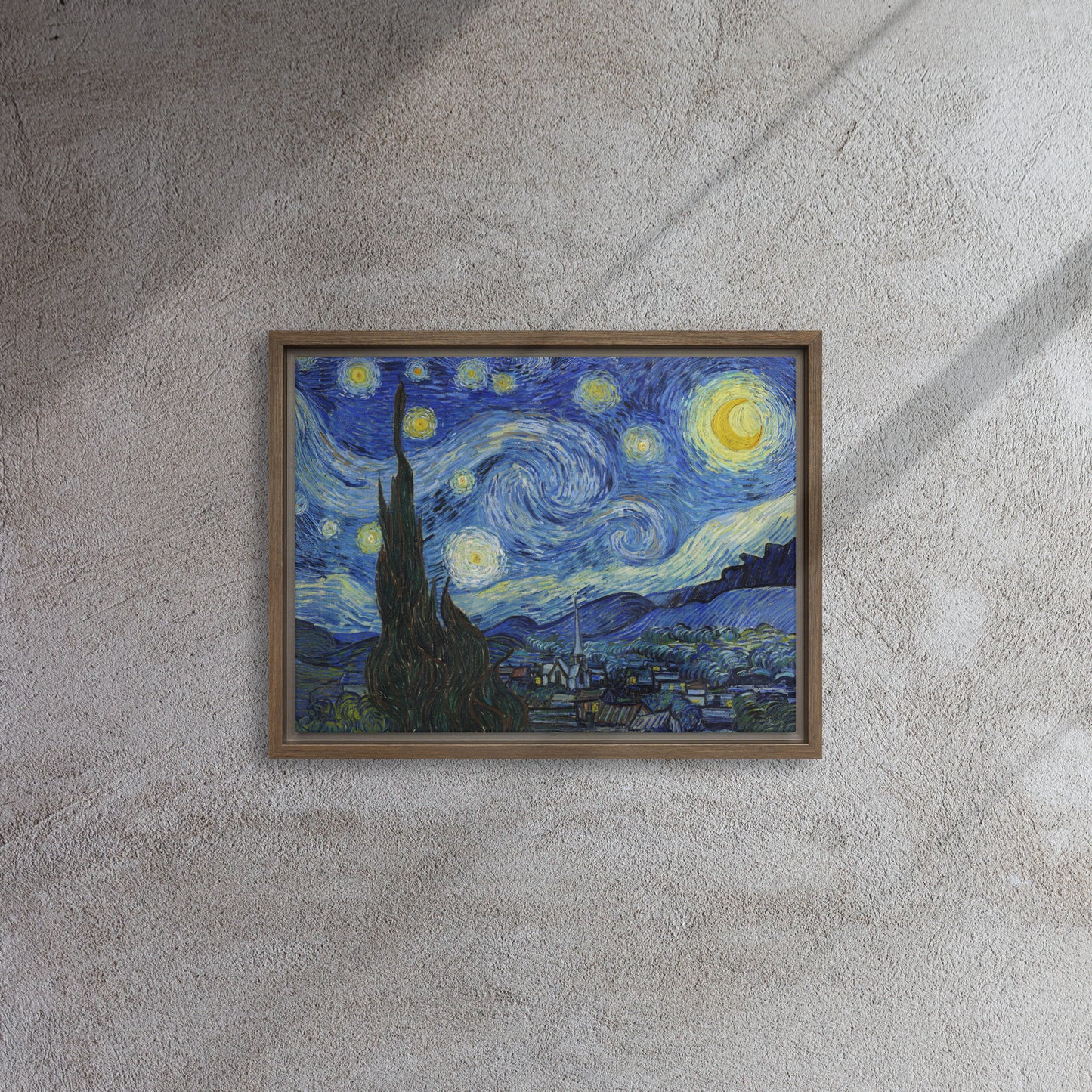 Van Gogh's 'Starry Night' on a 12"x16" brown framed canvas print on a textured gray wall.