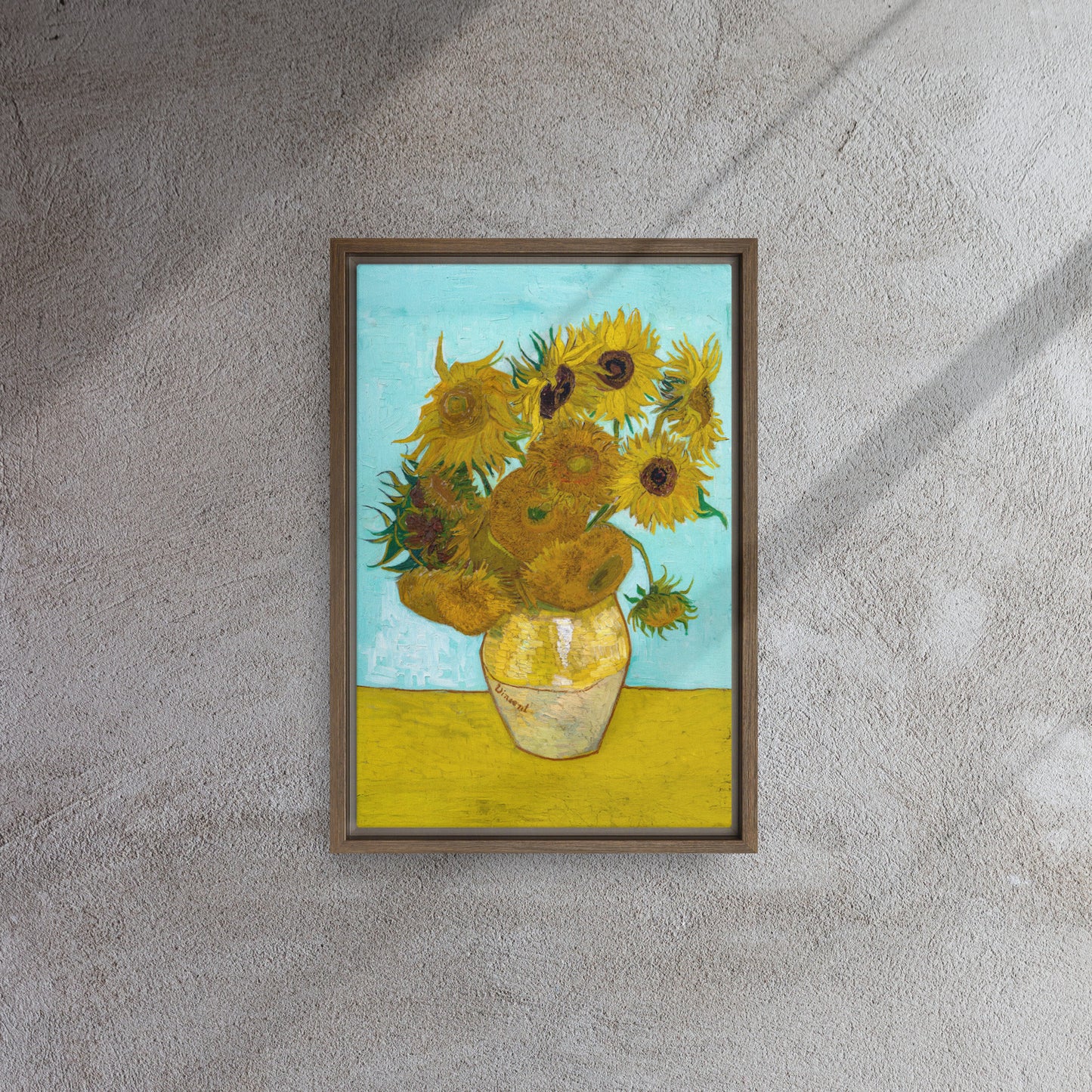 Van Gogh's 'Vase with Twelve Sunflowers' on a 12"x18" brown framed canvas print on a textured gray wall.