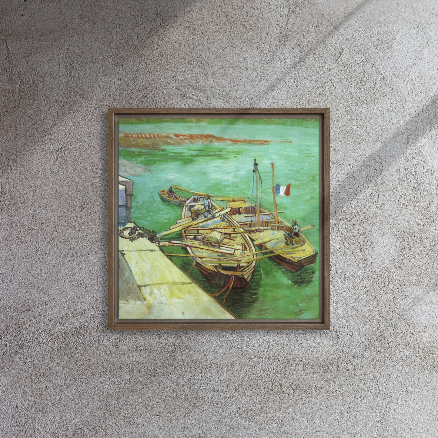 Van Gogh's 'Quay with Men Unloading Sand Barges' on a 16"x16" brown framed canvas print on a textured gray wall.