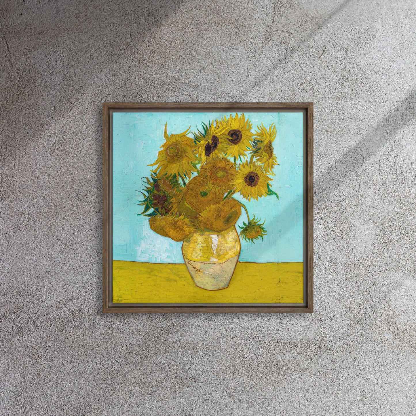 Van Gogh's 'Vase with Twelve Sunflowers' on a 16"x16" brown framed canvas print on a textured gray wall.