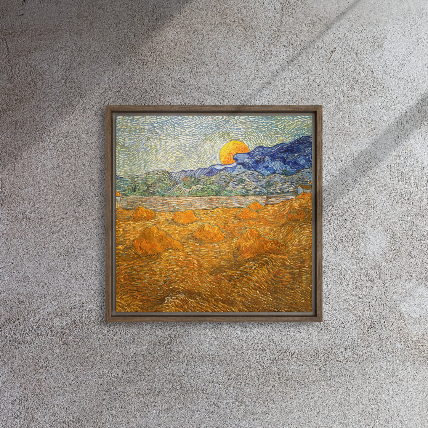 Van Gogh's 'Landscape with Wheat Sheaves and Rising Moon' on a 16"x16" brown framed canvas print on a textured gray wall.