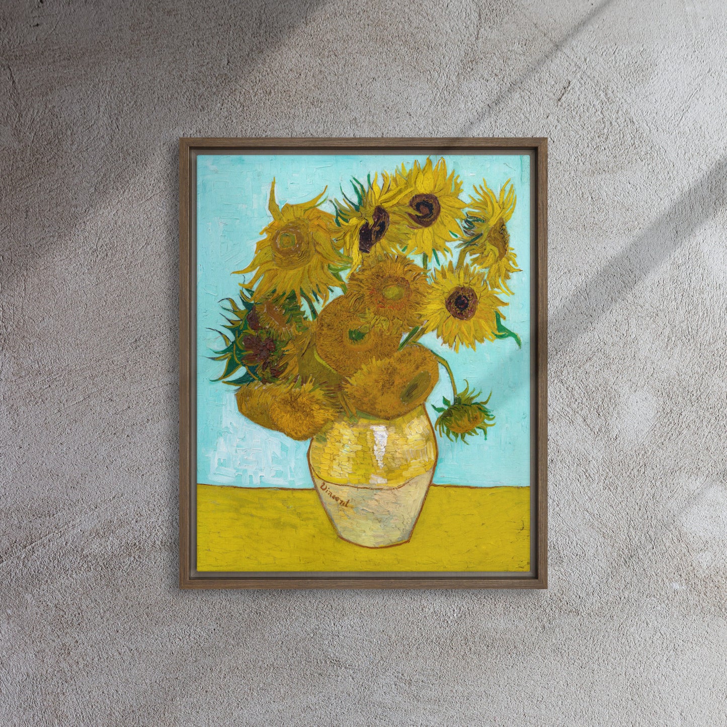 Van Gogh's 'Vase with Twelve Sunflowers' on a 16"x20" brown framed canvas print on a textured gray wall.