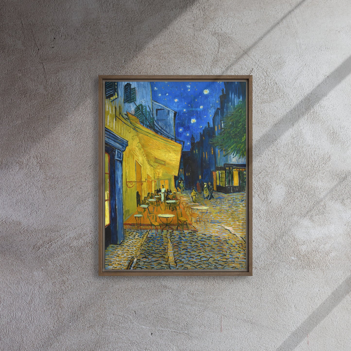Van Gogh's 'Café Terrace at Night' on a 18"x24" brown framed canvas print on a textured gray wall.