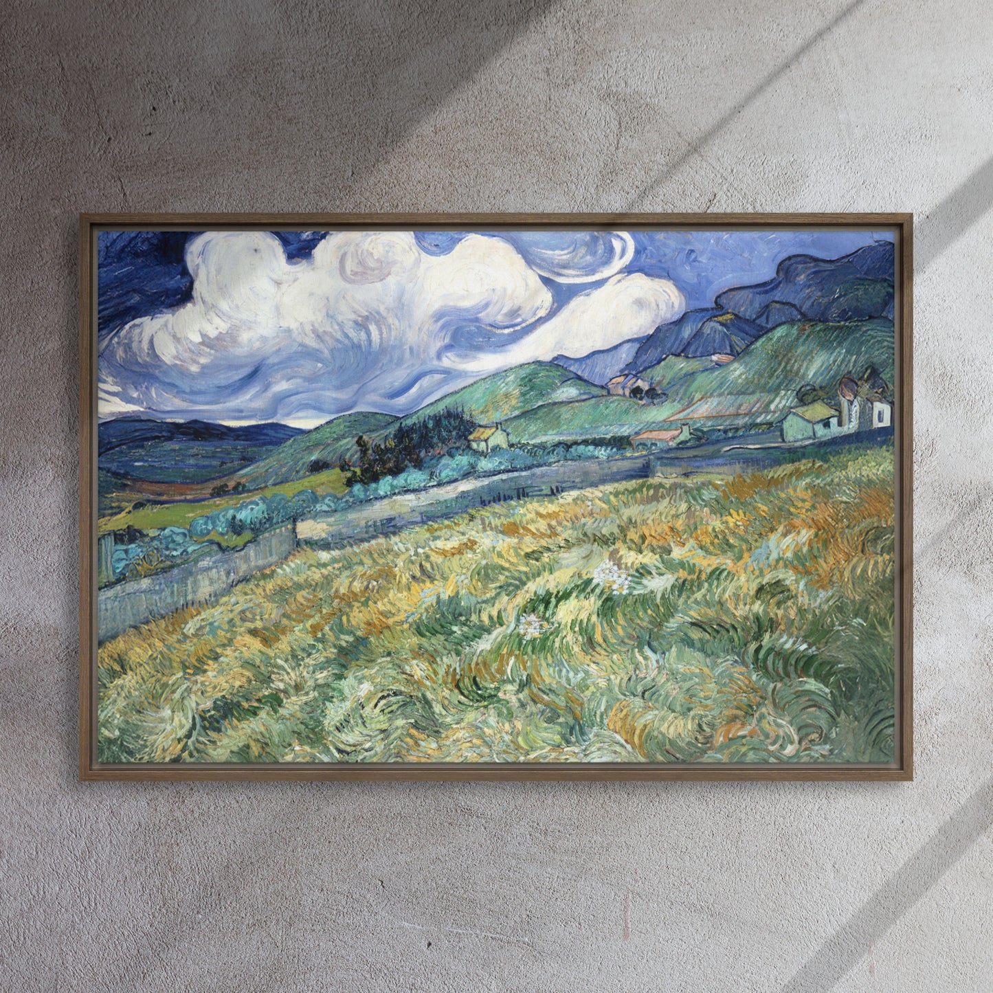 Van Gogh's 'Landscape from Saint-Rémy' on a 24"x36" brown framed canvas print on a textured gray wall.