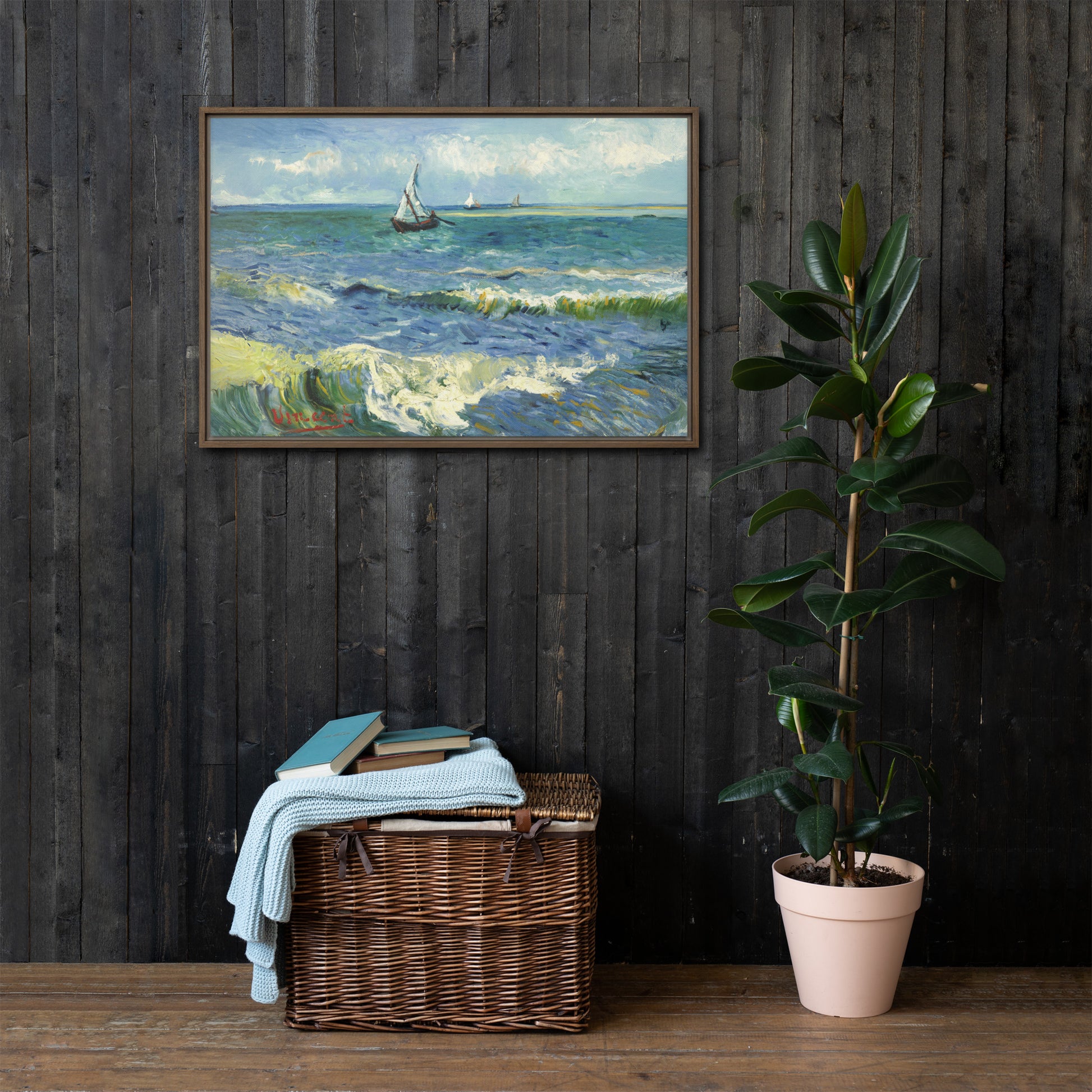 Van Gogh's 'The Sea at Les Saintes-Maries-de-la-Mer' on a 24"x36" brown framed canvas print on a dark wooden wall with a wicker bin and plant below.