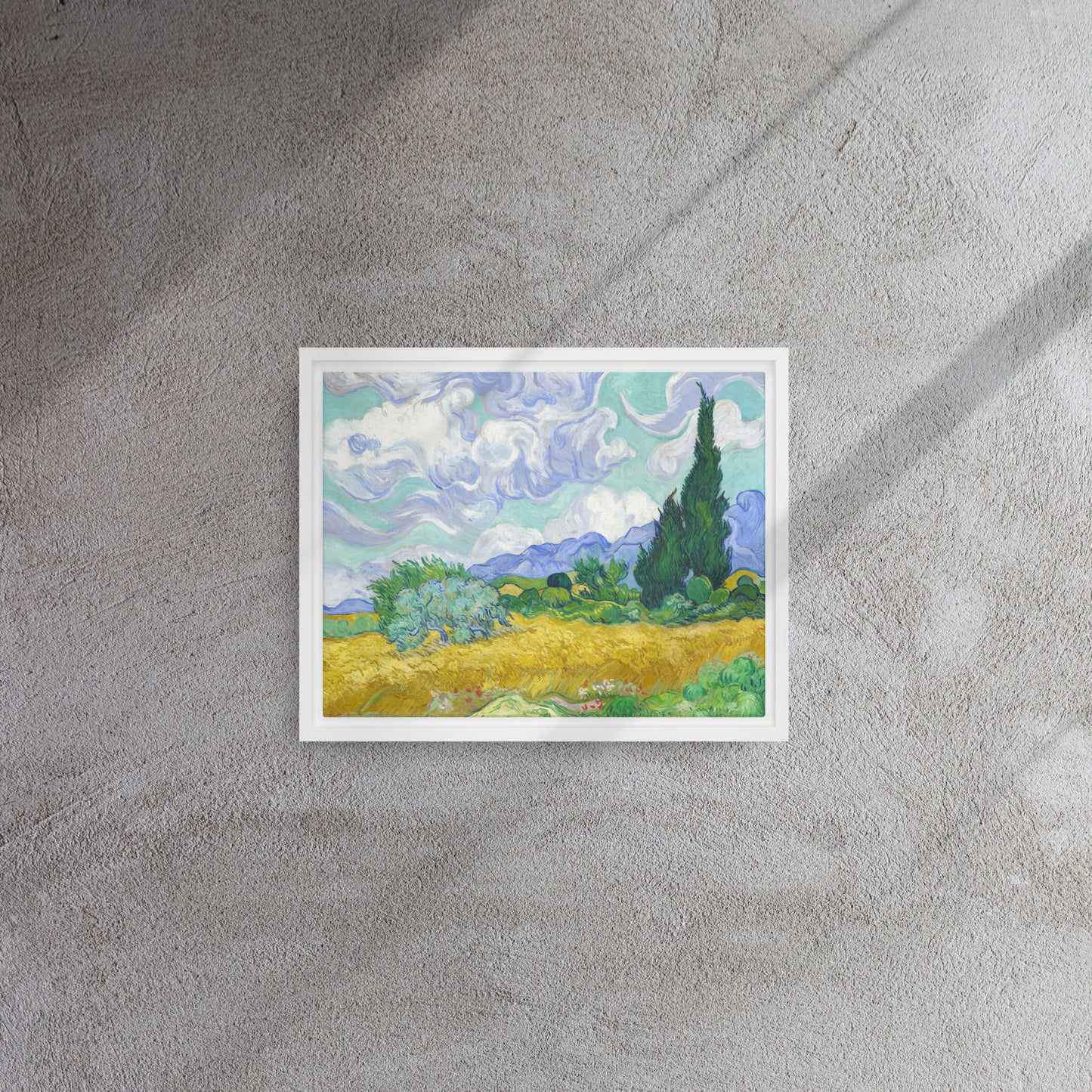 Van Gogh's 'Wheat Field with Cypresses' on a 11"x14" white framed canvas print on a textured gray wall.