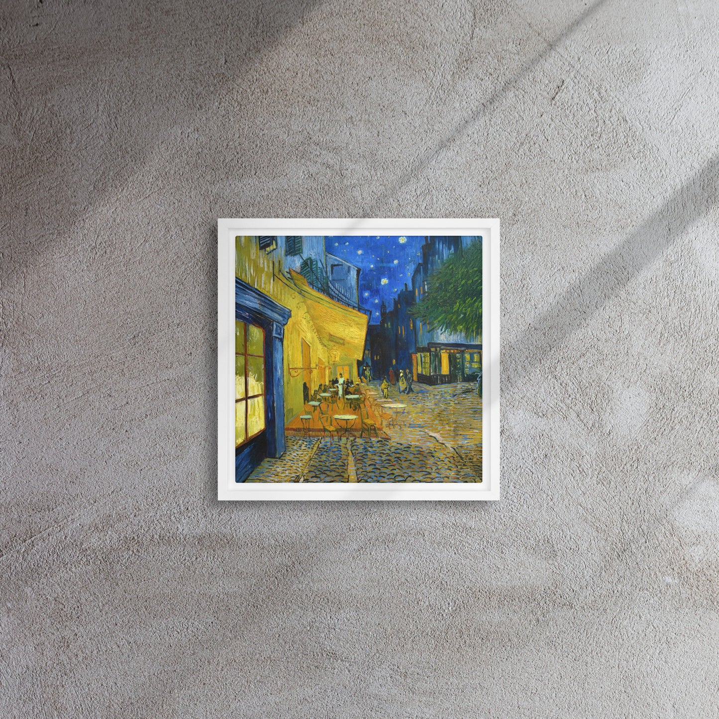 Van Gogh's 'Café Terrace at Night' on a 12"x12" white framed canvas print on a textured gray wall.