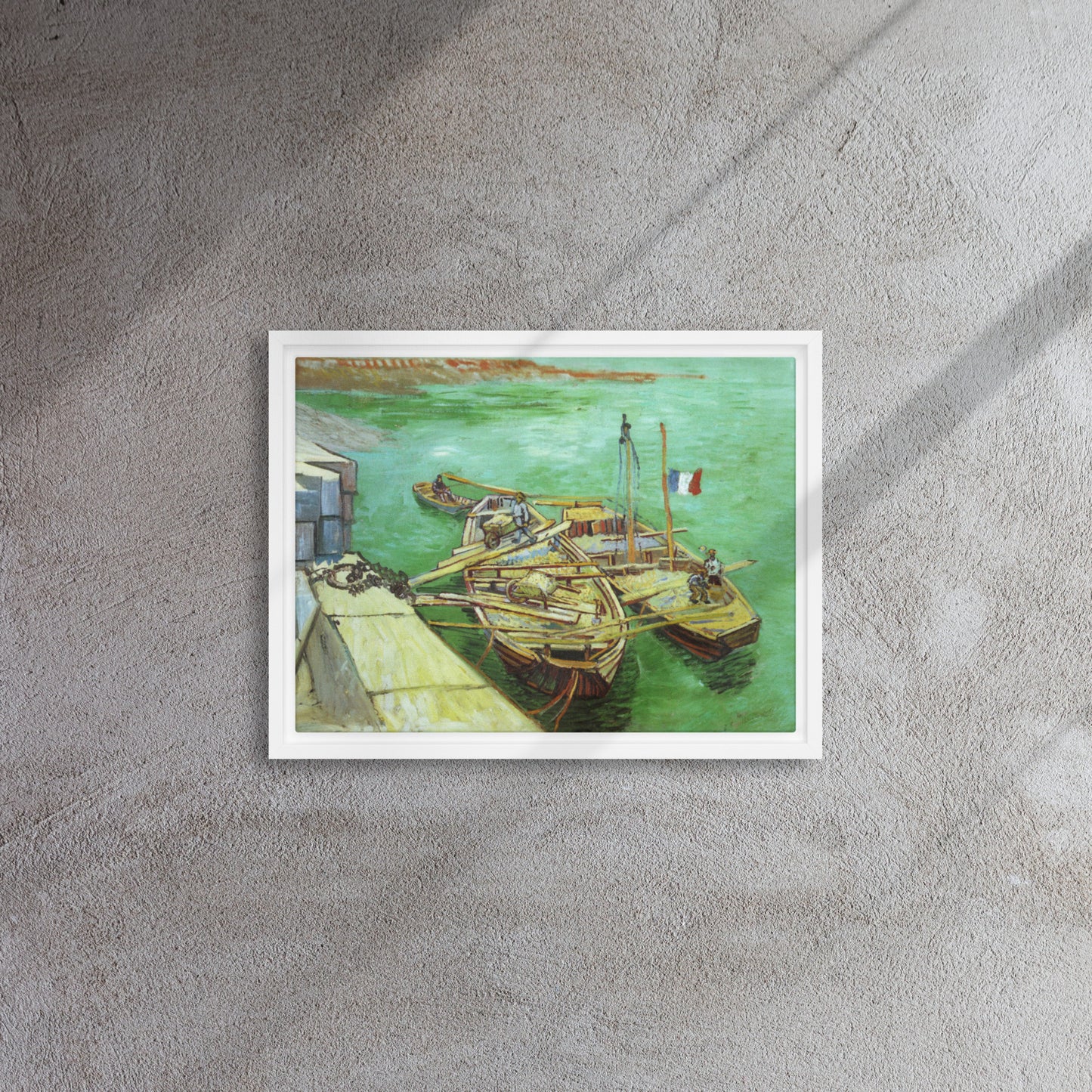 Van Gogh's 'Quay with Men Unloading Sand Barges' on a 12"x16" white framed canvas print on a textured gray wall.