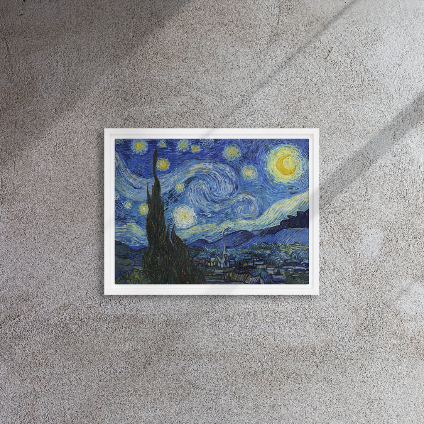 Van Gogh's 'Starry Night' on a 12"x16" white framed canvas print on a textured gray wall.