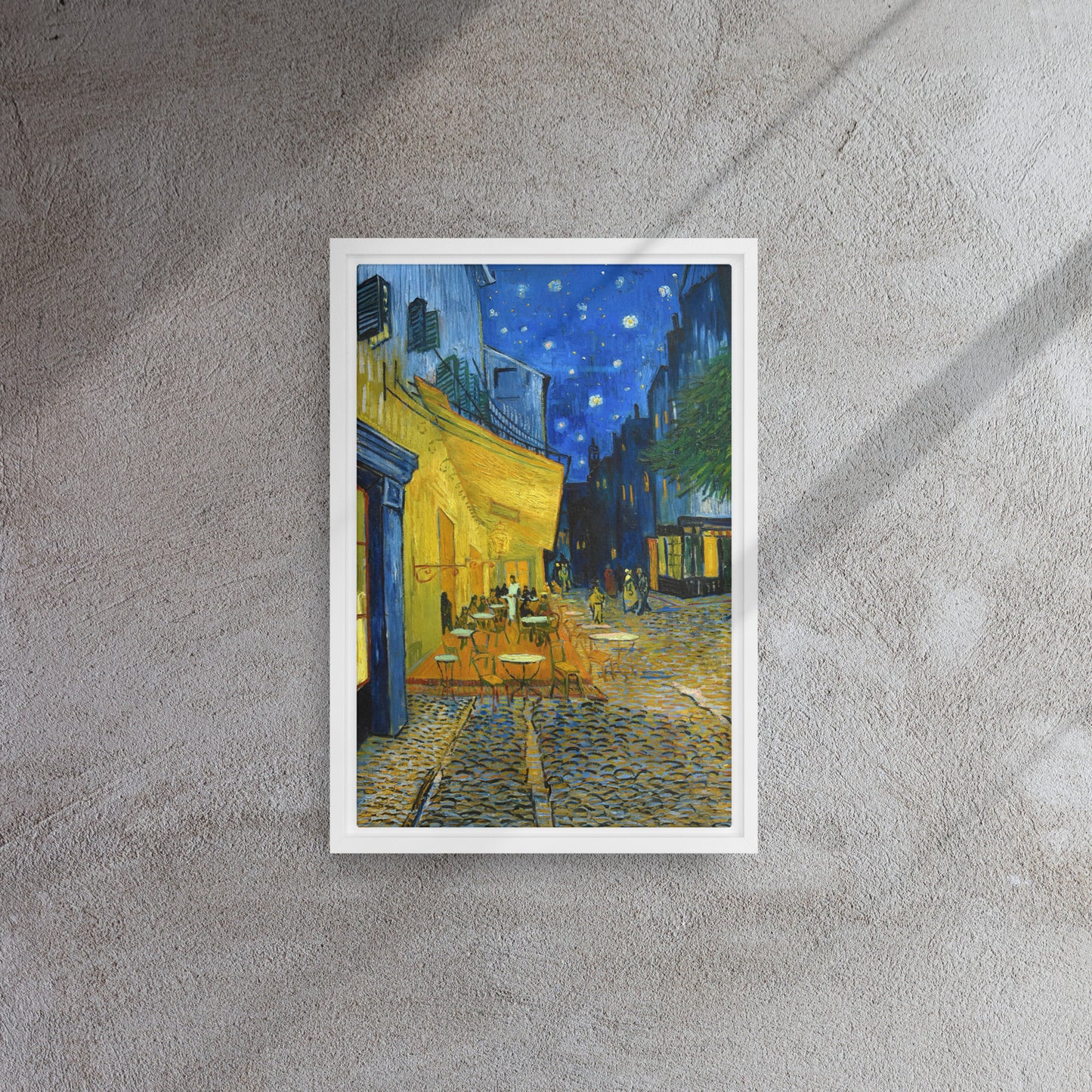 Van Gogh's 'Café Terrace at Night' on a 12"x18" white framed canvas print on a textured gray wall.