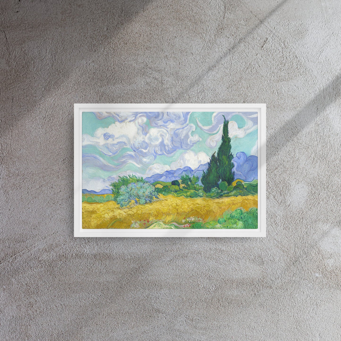 Van Gogh's 'Wheat Field with Cypresses' on a 12"x18" white framed canvas print on a textured gray wall.