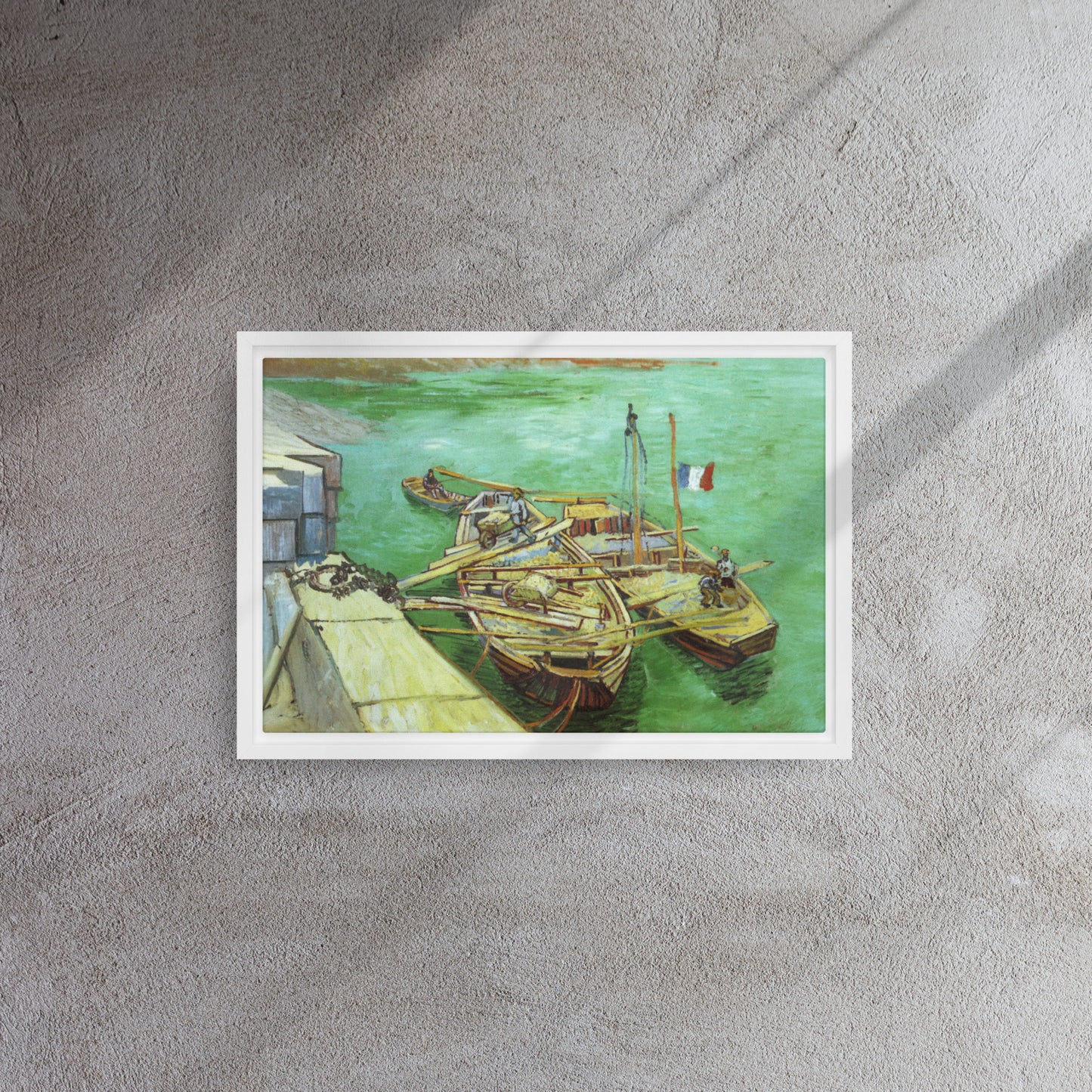 Van Gogh's 'Quay with Men Unloading Sand Barges' on a 12"x18" white framed canvas print on a textured gray wall.