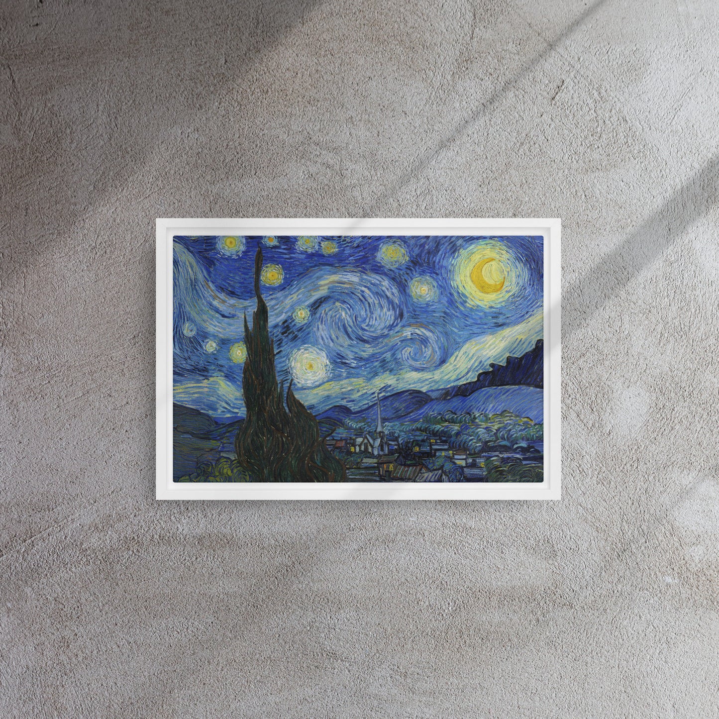 Van Gogh's 'Starry Night' on a 12"x18" white framed canvas print on a textured gray wall.