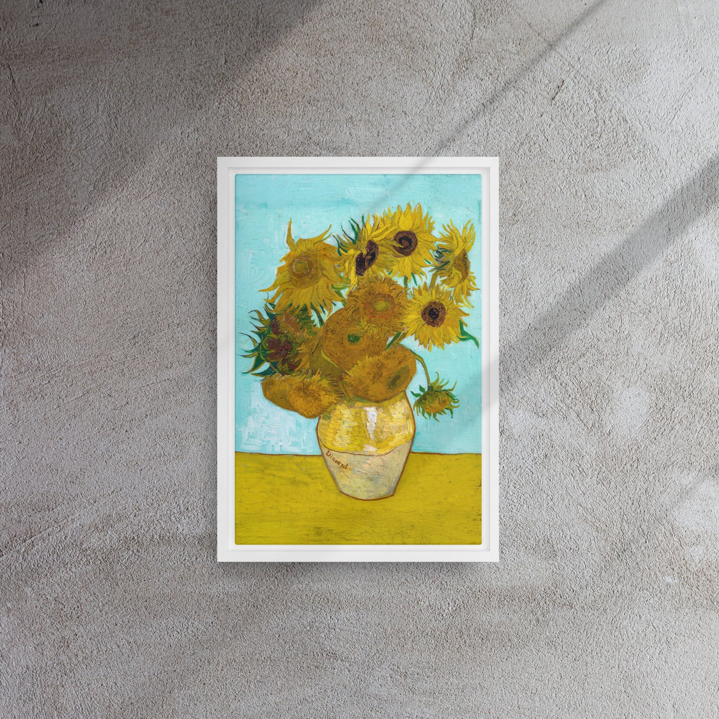 Van Gogh's 'Vase with Twelve Sunflowers' on a 12"x18" white framed canvas print on a textured wall.