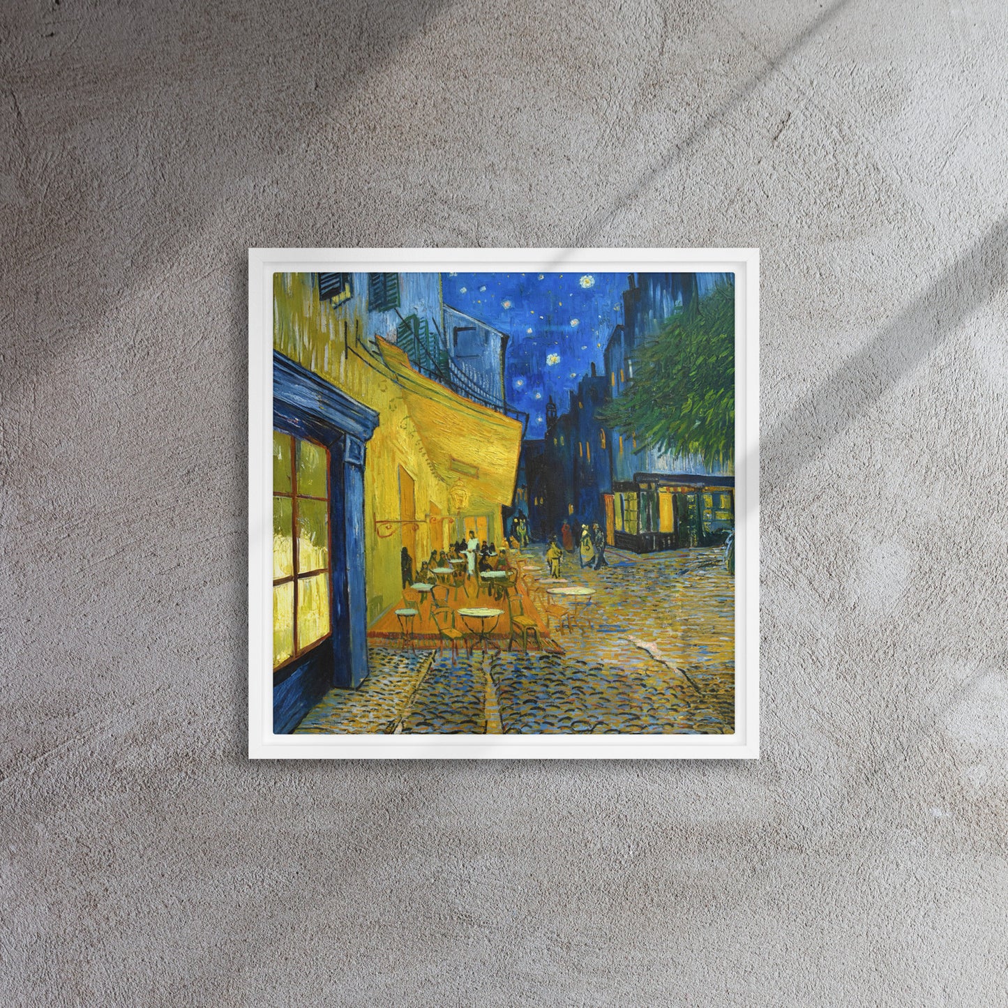 Van Gogh's 'Café Terrace at Night' on a 16"x16" white framed canvas print on a textured gray wall.